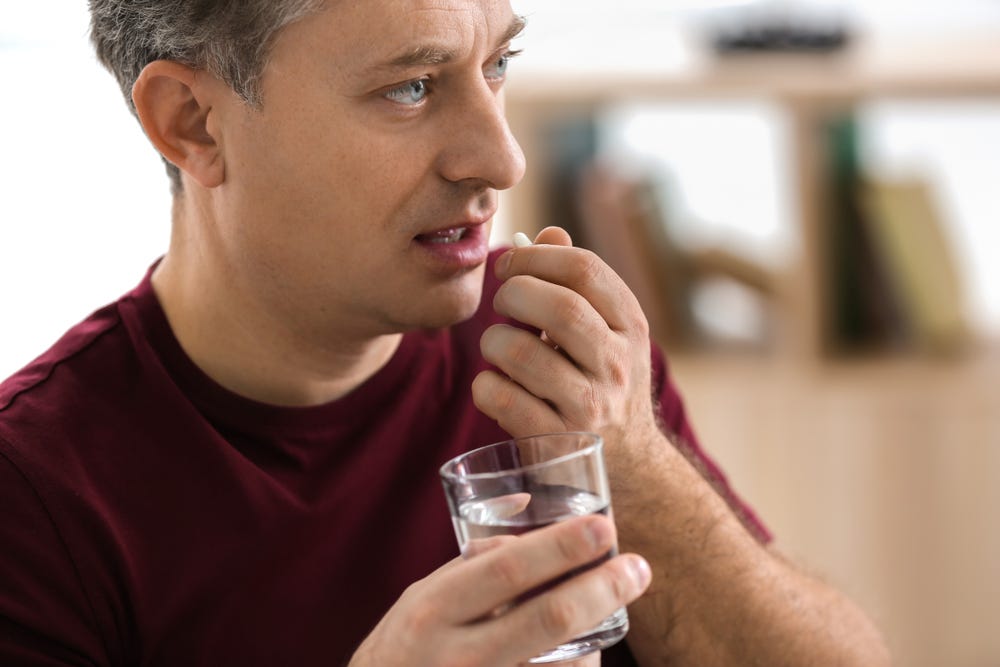 mature man taking health supplement