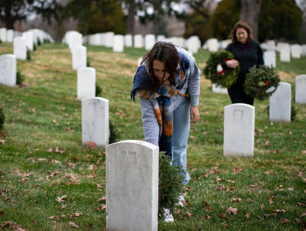 woman laying wreath at Arlington Cemetery on Memorial Day