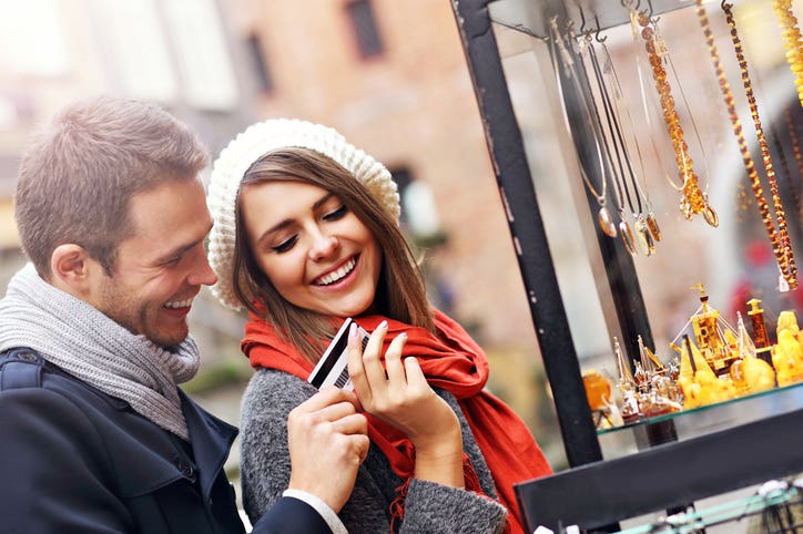 Young tourists shopping for souvenirs with credit card