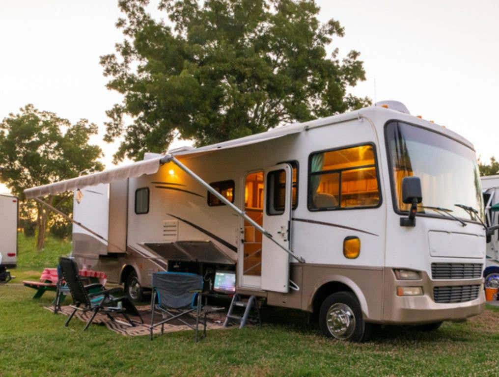 light up RV with camping chairs at a camp ground