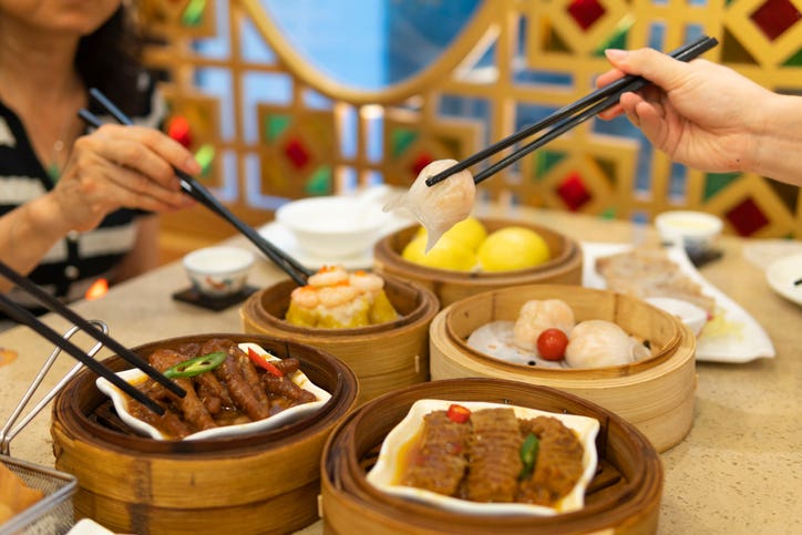 People eating Guangdong dum sum with chopsticks in the restaurant