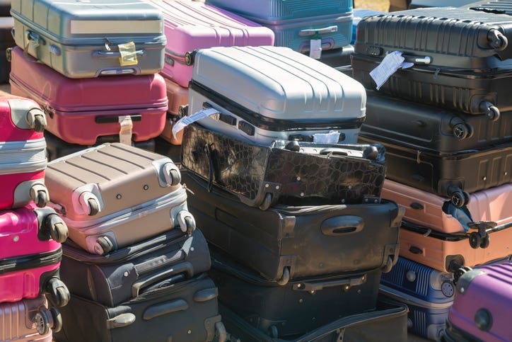 a pile of suitcases at lost and found department at the airport