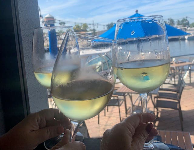 Three glasses of white wine raised in a toast