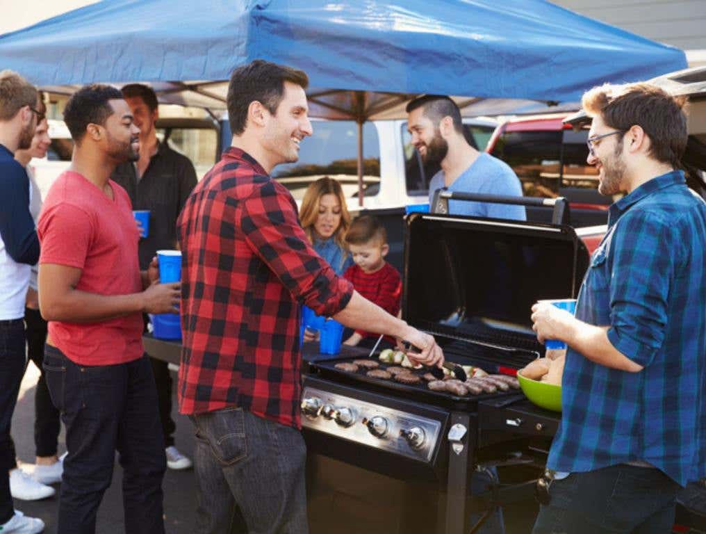 guys tailgating outside and grilling