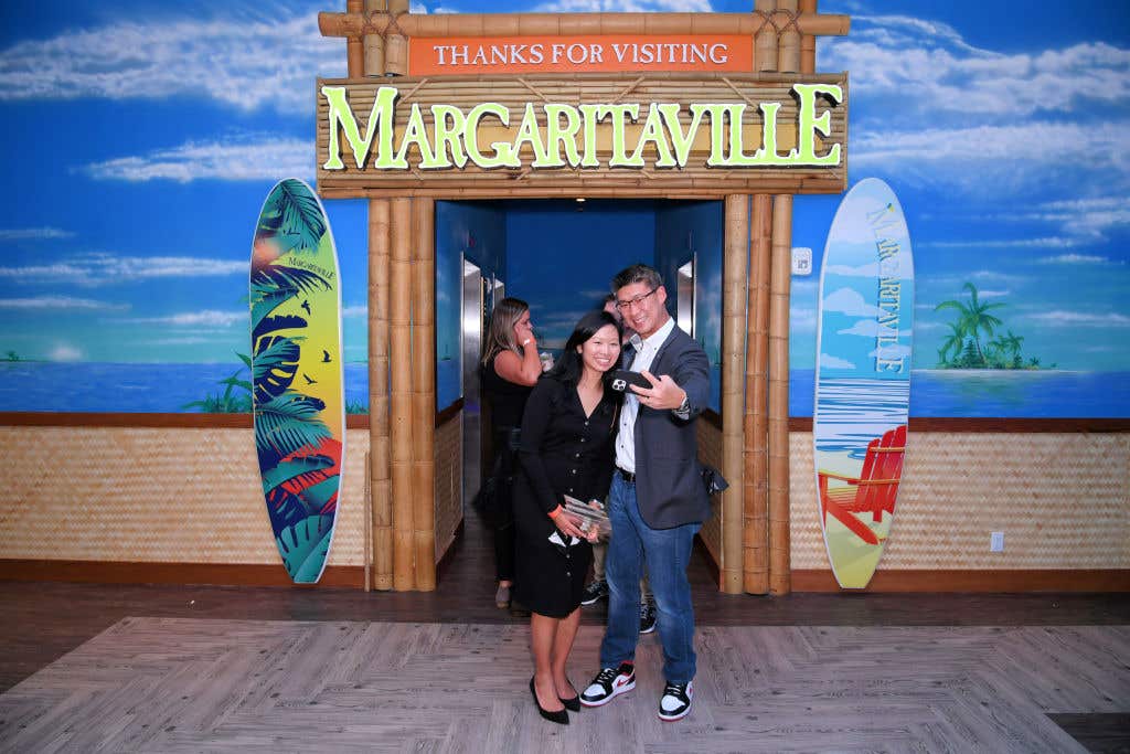 A couple taking a selfie at the entrance to Margaritaville Resort. Margaritaville accepting reservations