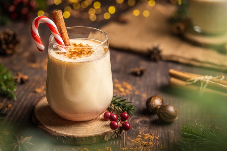 Eggnog or coquito with spicy cinnamon. Christmas and winter holidays, Cozy cocktail with cinnamon and candy cane, Traditional Christmas drink with grated nutmeg and cinnamon, Homemade Holiday drink