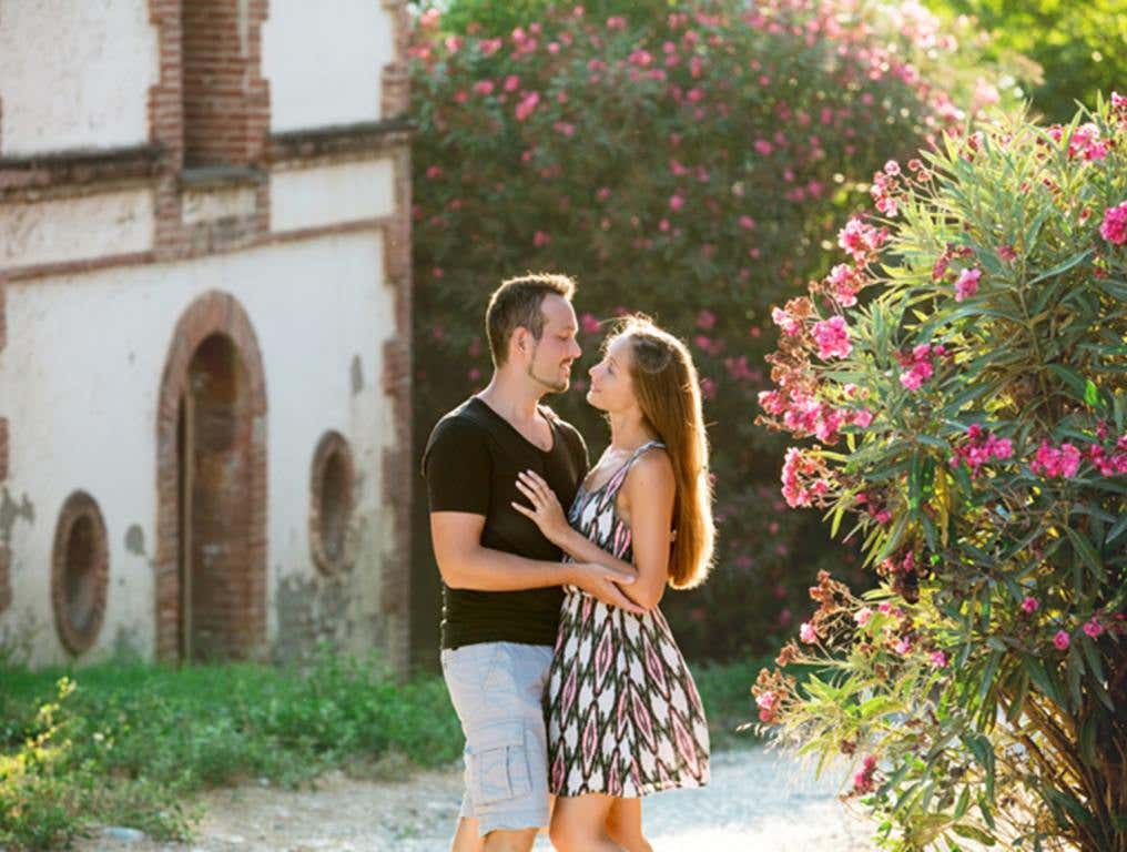 Beautiful romantic couple man and woman young adults on a date walking through the blooming old town together