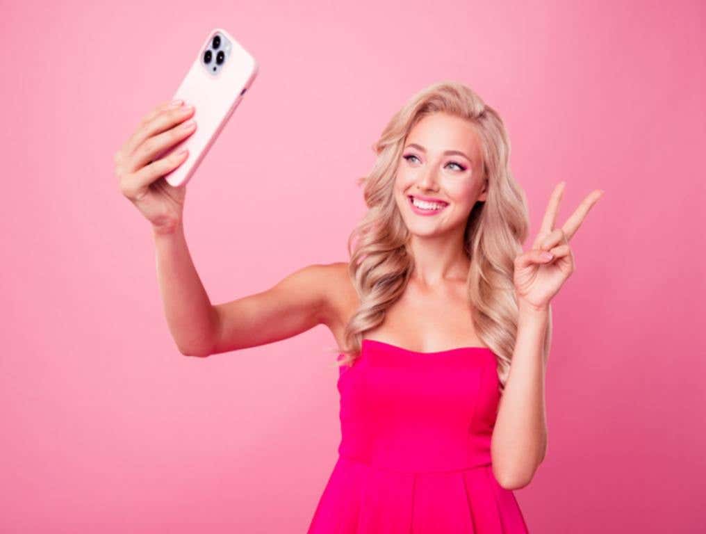 A girl in pink taking a selfie.