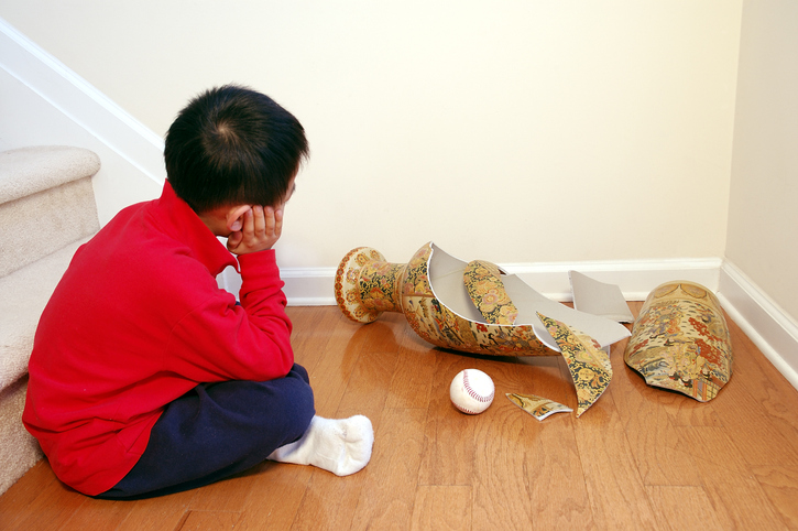 A child, a broken vase and a baseball.