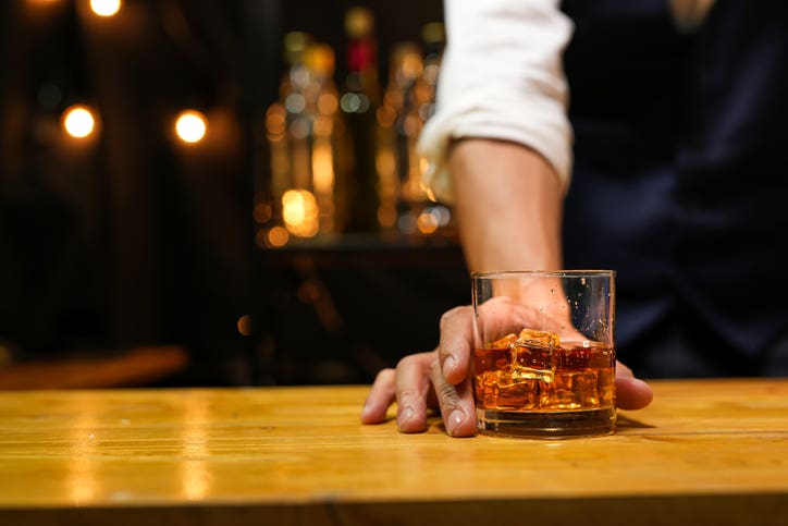 Bartender pouring Whiskey, on bar, at a whiskey bar in Fort Myers Florida.