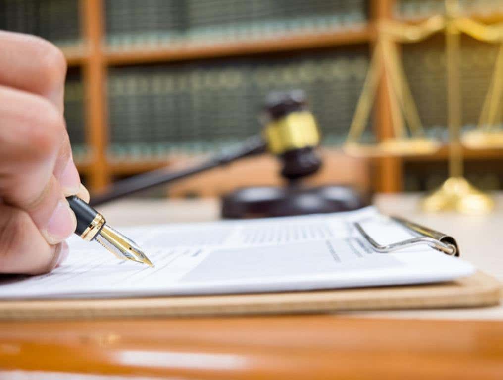 Lawyer Detail of a judge sitting at his desk, studying new laws and legislation and taking notes. Selective focus