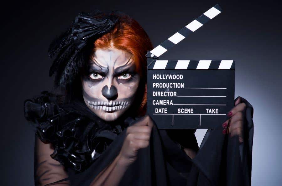 woman in scary halloween skeleton makeup holding a movie clapperboard for October weekend events in SWFL