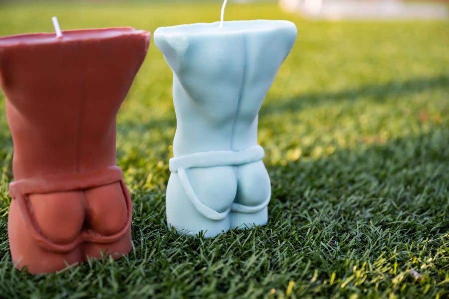 two candles of a torso wearing nothing but a jockstrap, a view from behind as they sit on grass so fans can Sniff Odell Beckham's Jockstrap