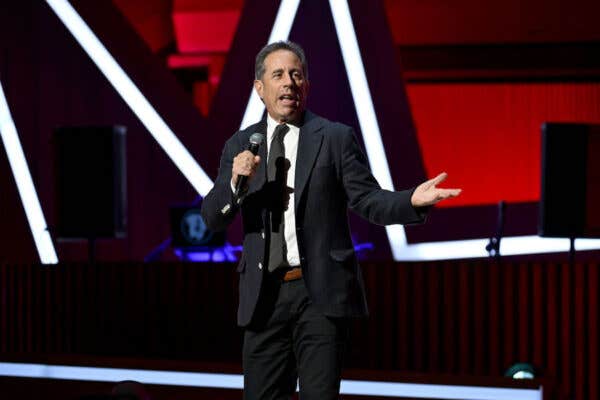 Jerry Seinfeld standing on a stage witha microphone and his hand extended for Top Weekend Events In Southwest Florida