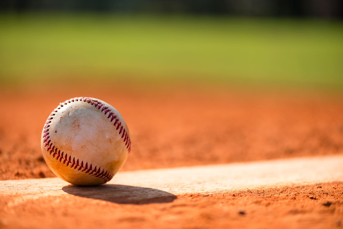 Baseball with dirt on it sitting atop pitchers mound close up