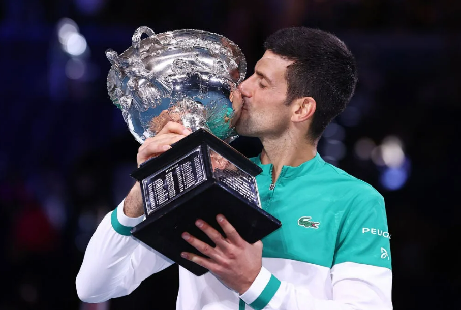 Novak Djokovic kissing his Norman Brookes Challenge Cup during the 2021 Australian Open