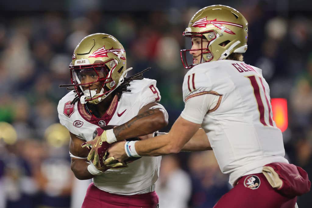 Brock Glenn #11 of the Florida State Seminoles hands the ball off to Lawrance Toafili