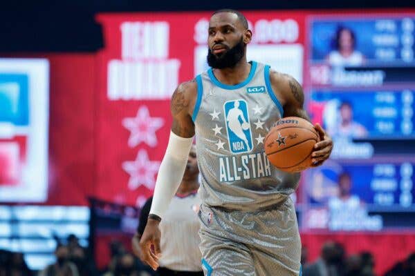 LeBron James wearing a gray jersey and holding a basketball