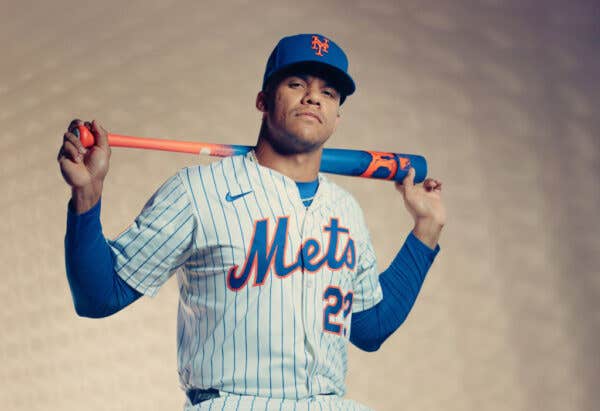 Juan Soto wearing his Mets uniform holding a baseball bat