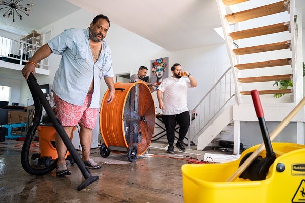 Lazaro Vento vacuums water at his storm-damaged home in the wake of Hurricane Ian on October 2, 2022 in Bonita Springs, Florida. The category four storm made a U.S. landfall on Cayo Costa, Florida Wednesday afternoon. Vento watched from the safety of the home's interior balconies as the storm surge filled his home with feet of water. 