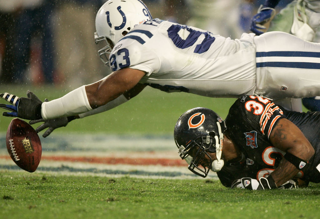 Dwight Freeney #93 of the Indianapolis Colts stretches over running back Cedric Benson #32 of the Chicago Bears to recover a fumble during the first quarter of Super Bowl XLI on February 4, 2007 at Dolphin Stadium in Miami Gardens, Florida. 